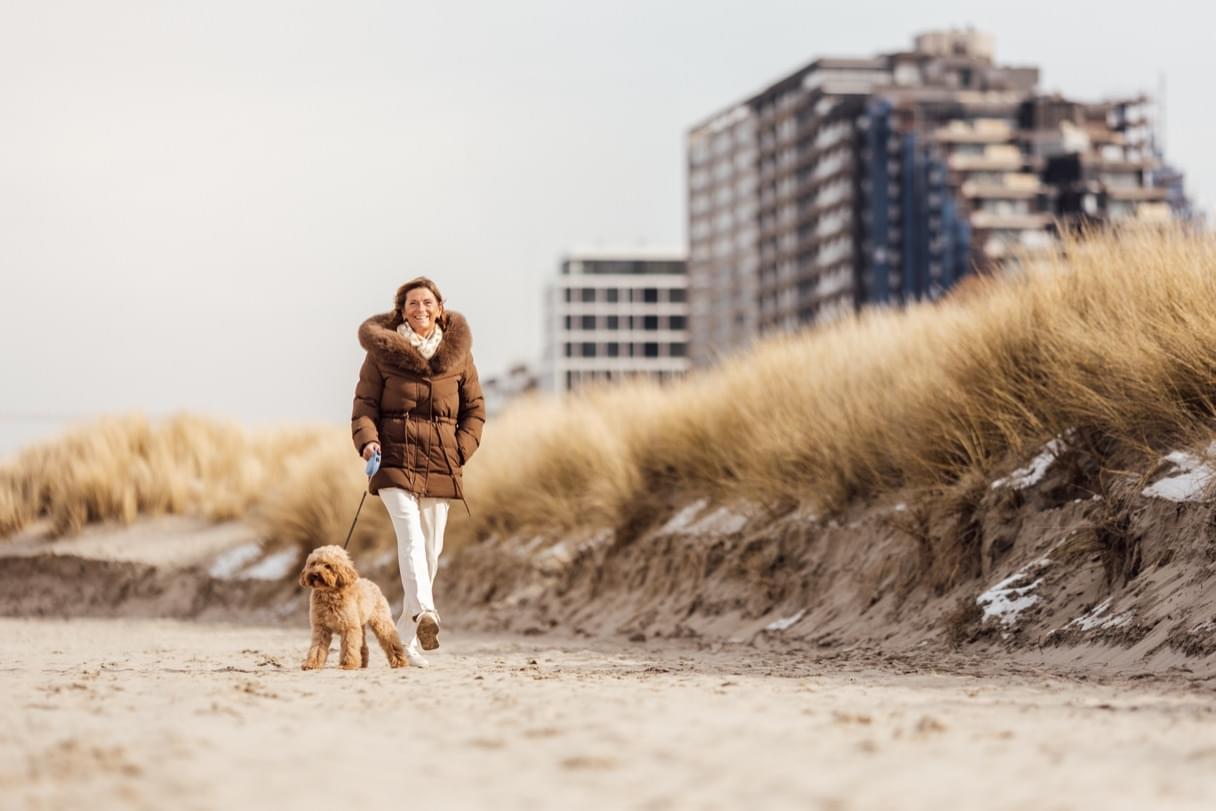 Anja wandelt op het strand met haar hond